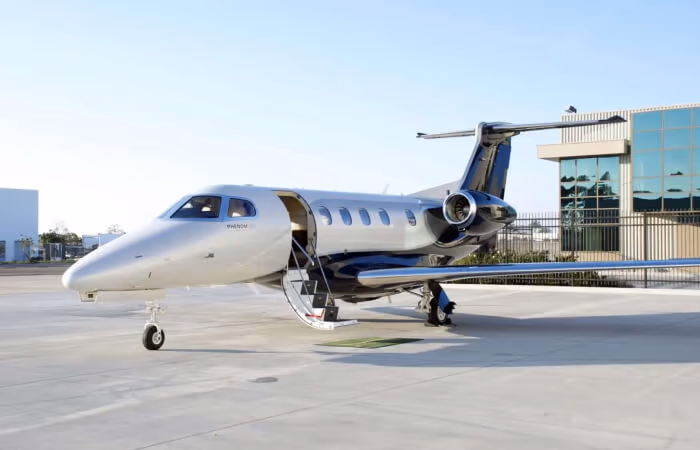 Phenom 300E parked at an FBO with airstairs deployed